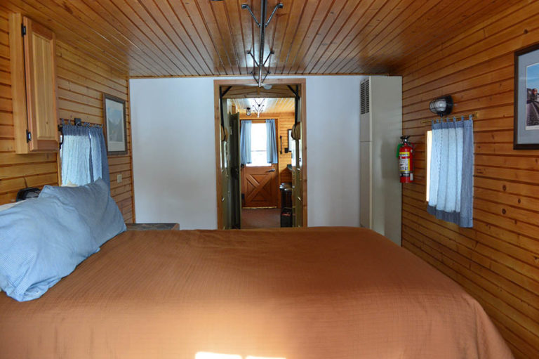 Queen bed in classic blue caboose - Cabin Rentals in Glacier
